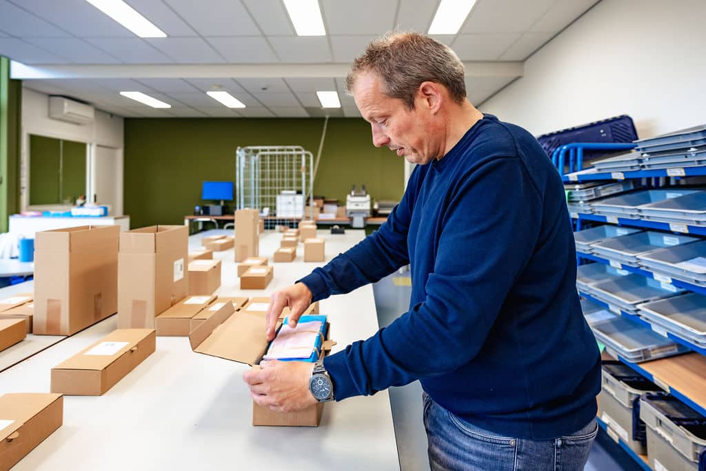 Medewerker verpakt certificaten in dozen